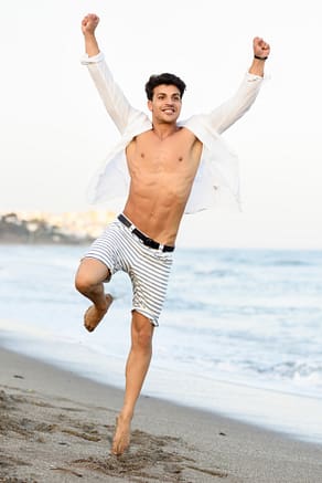 man-with-open-shirt-on-the-beach-and-a-raised-leg_1139-576
